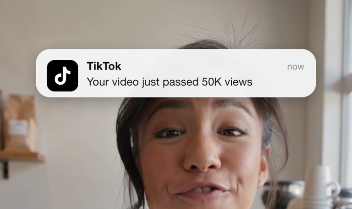 TikTok notification saying “Your video just passed 50K views” above the speaker’s head